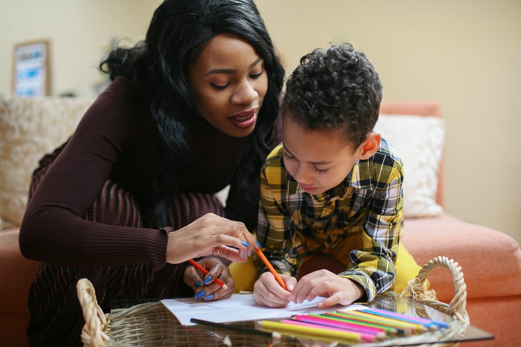Portrait of a young African American woman and her son drawing and communicate.